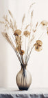 a vase filled with dried flowers on top of a table